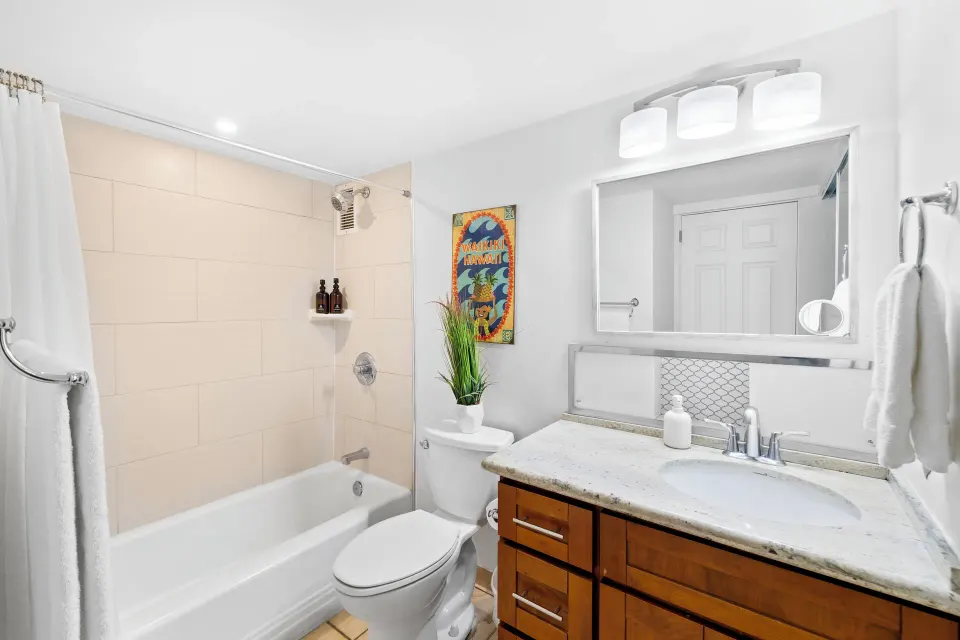 Bathroom with tub shower and vanity in a Standard Apartment at Ilikai Hotel.