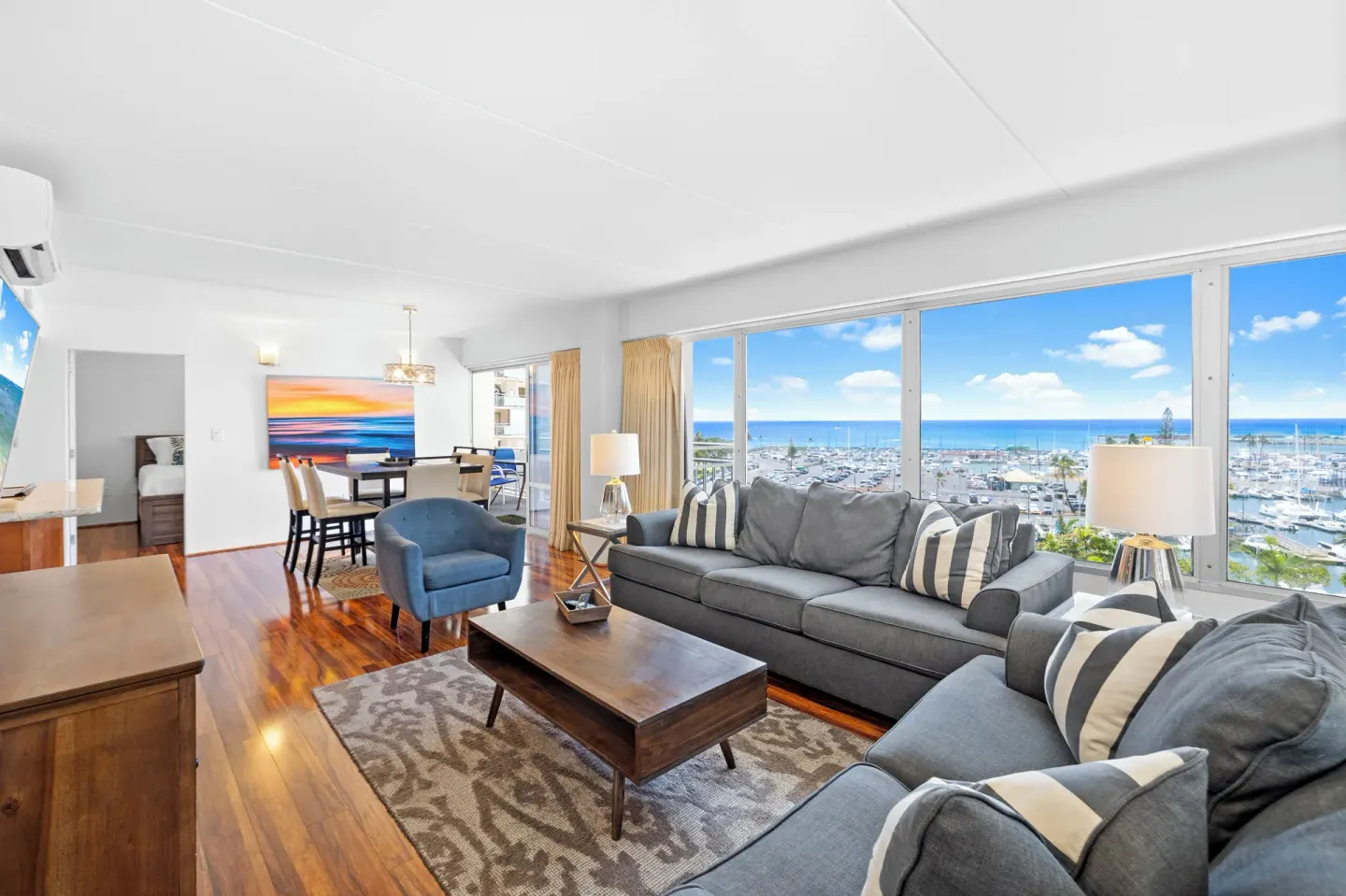 Living room with sofas and wide ocean-facing windows at Ilikai Hotel.