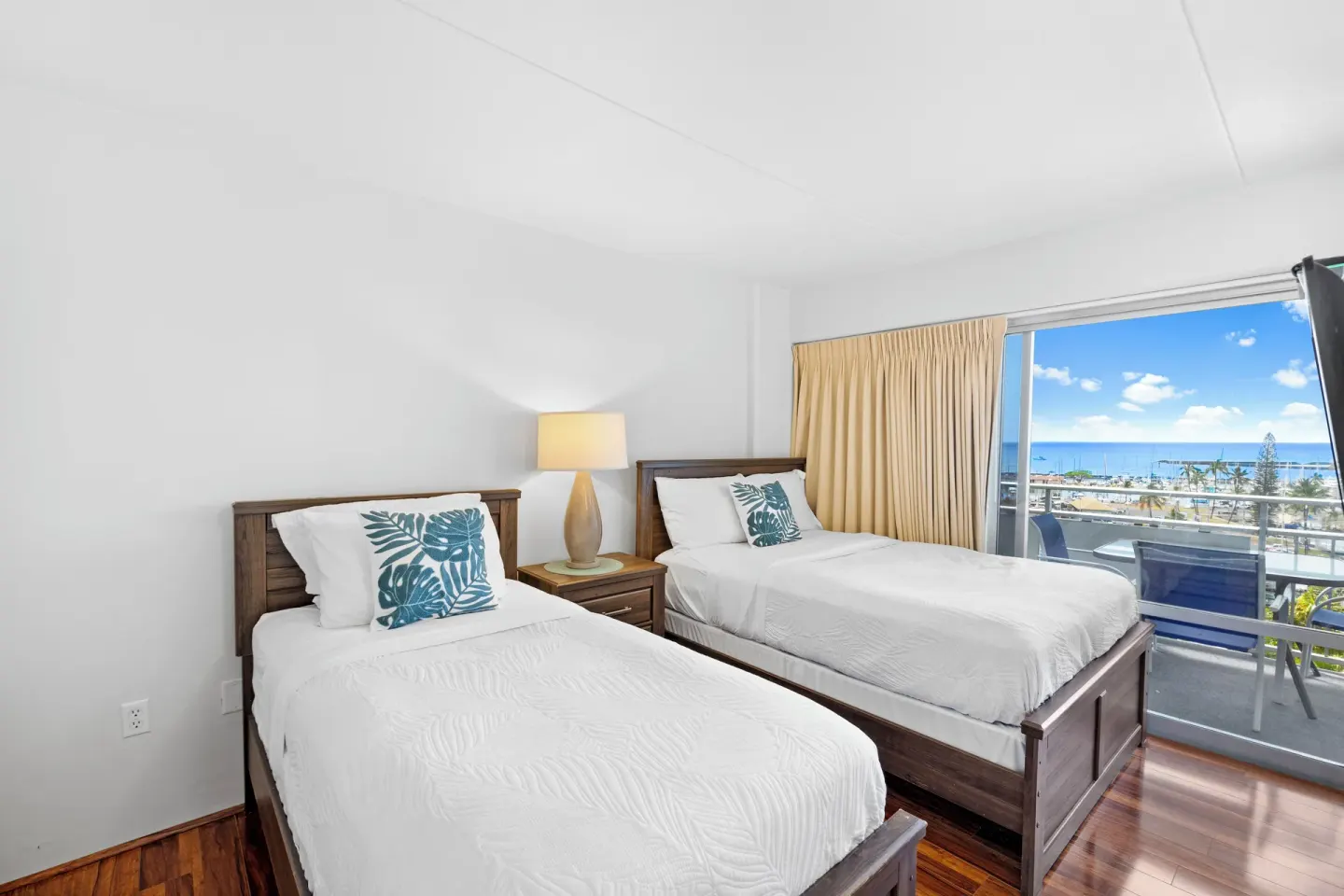Two twin beds and a lanai ocean view in a Standard Apartment at Ilikai Hotel.