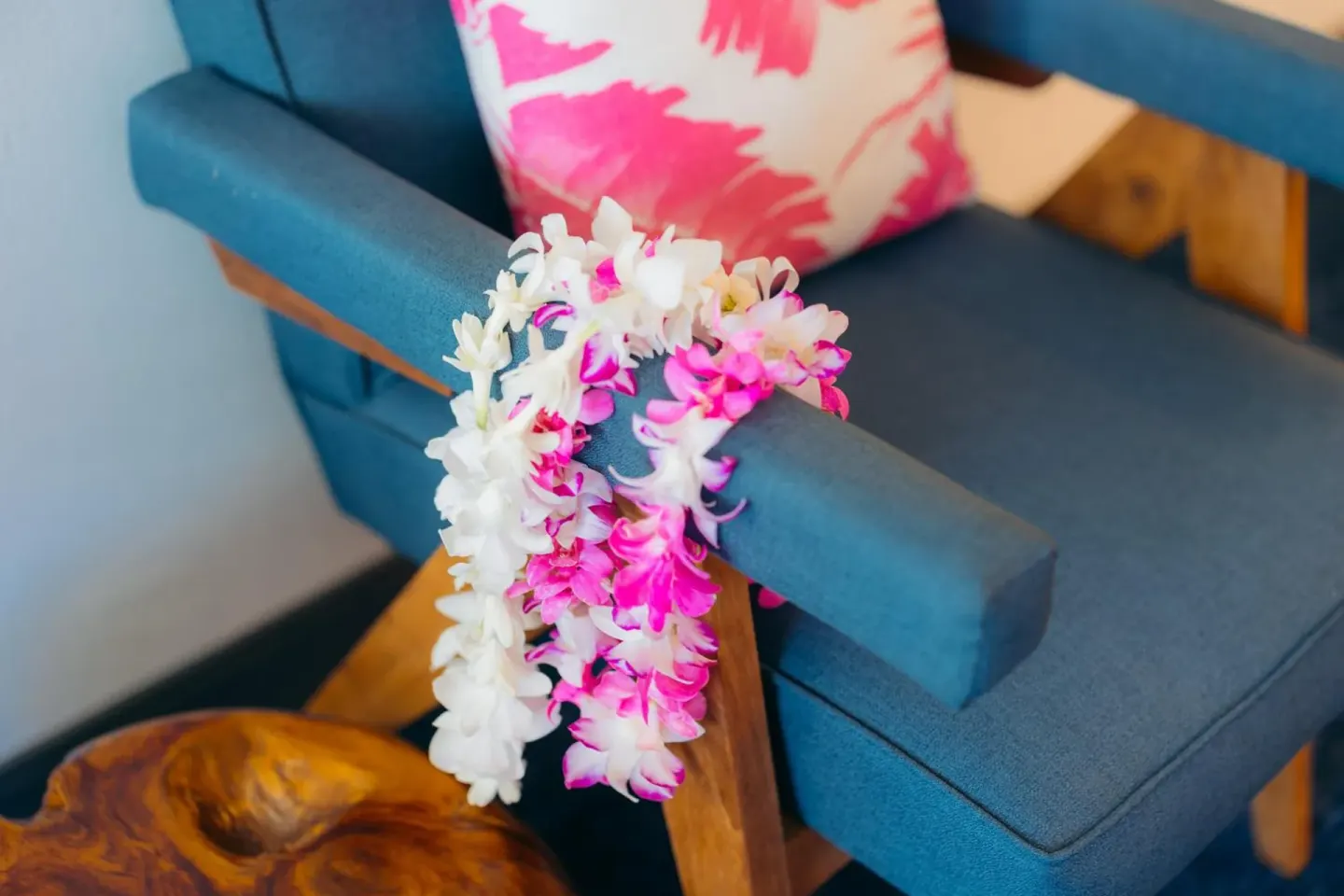 Flower leis rest on a blue armchair in a guest room at Ilima Hotel.