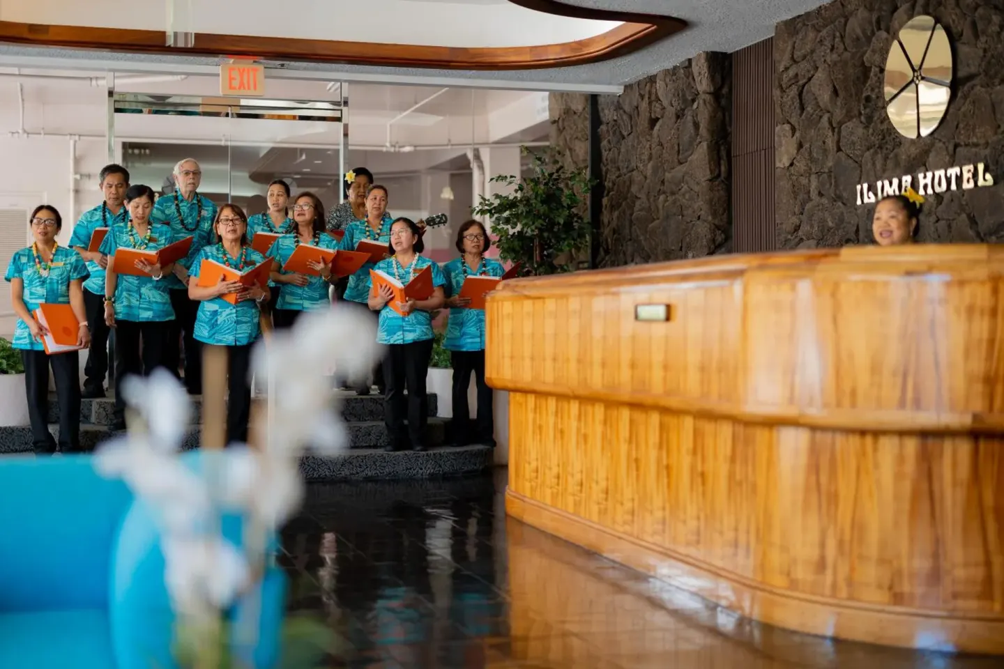 Choir performs beside the reception desk in the lobby at Ilima Hotel.