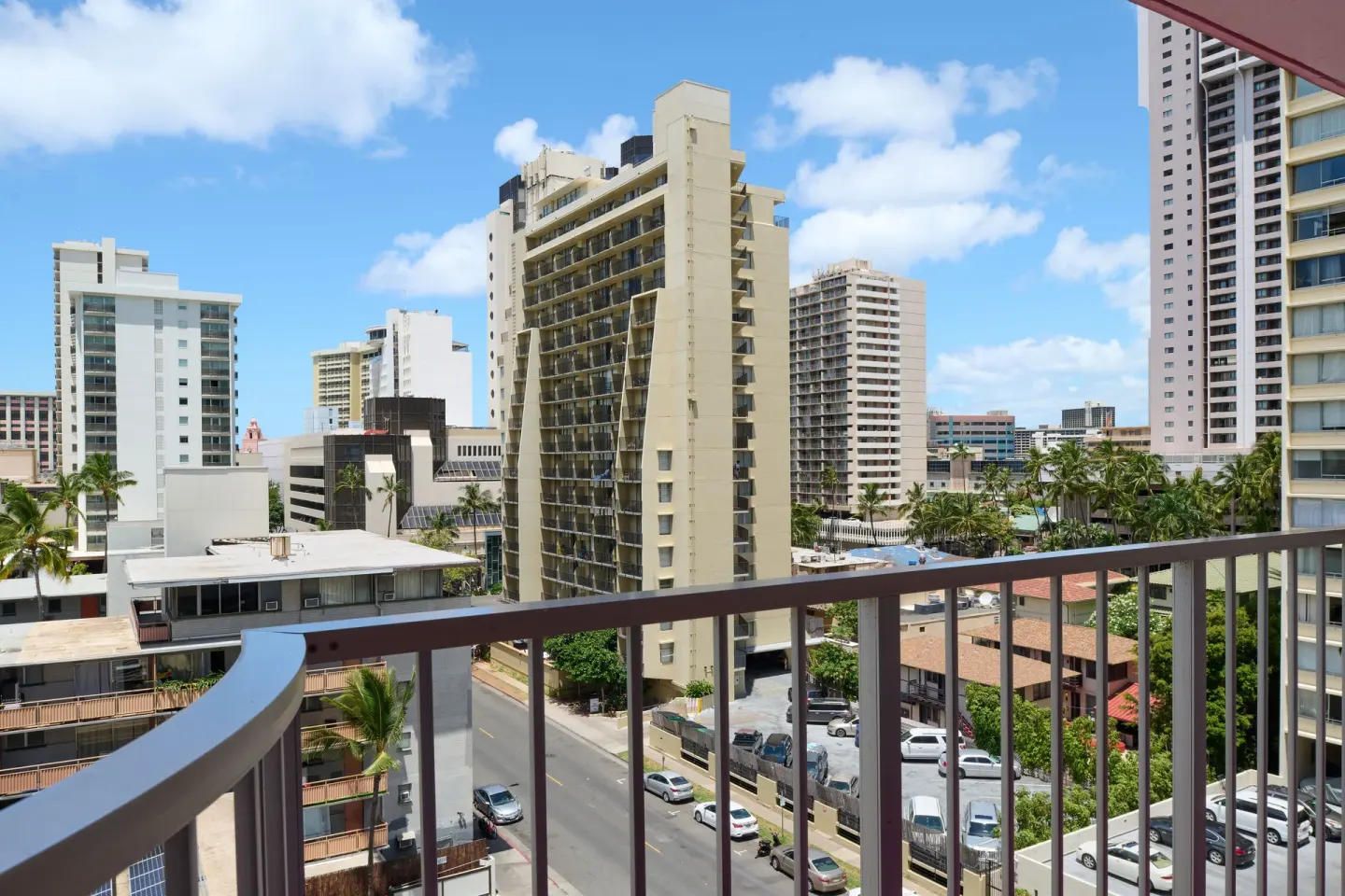 Standard Studio balcony city view with high-rises and street below at Ilima Hotel.