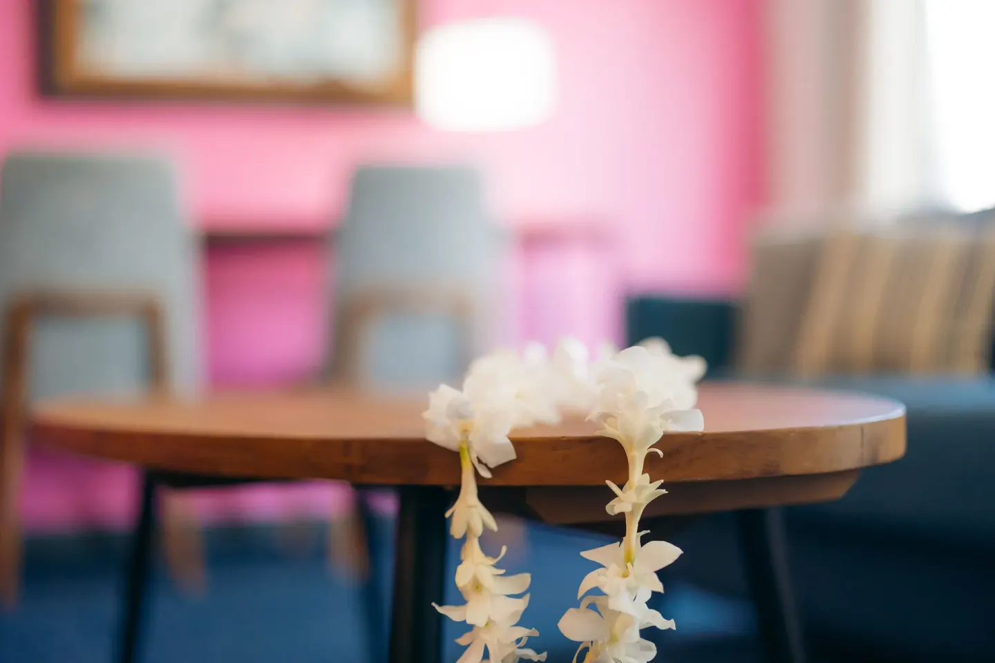 Flower lei on a round table in a Standard Studio seating area at Ilima Hotel.