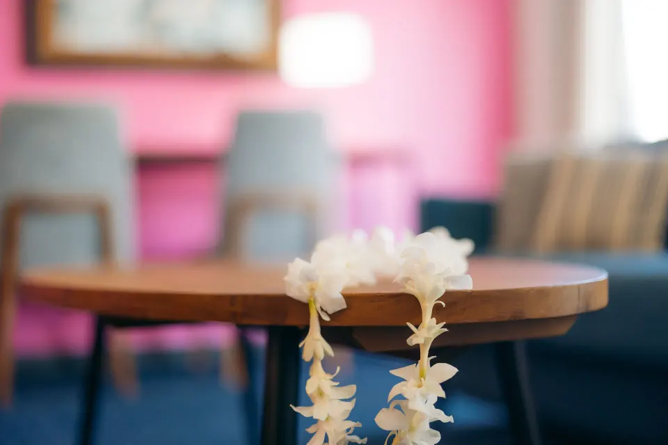 Flower lei on a round table in a Standard Studio seating area at Ilima Hotel.