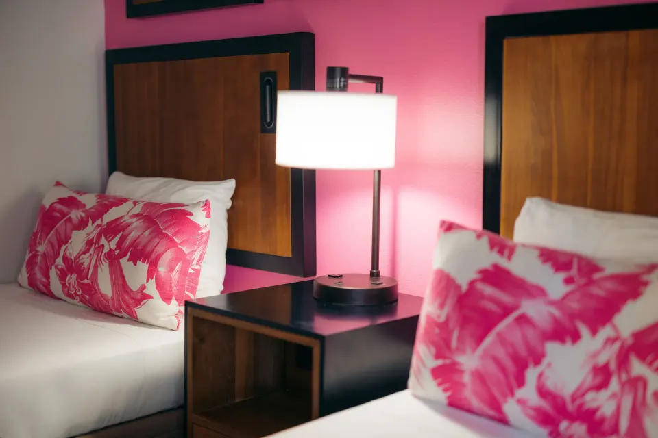 Two Standard Studio beds with a lit bedside lamp at Ilima Hotel.