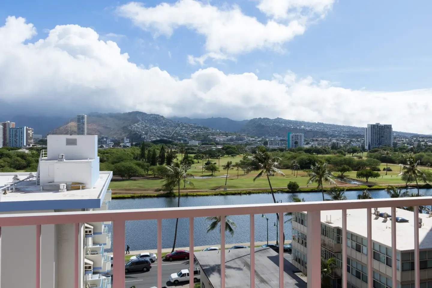 Balcony view of mountains, canal, palms, and golf greens at Ilima Hotel.