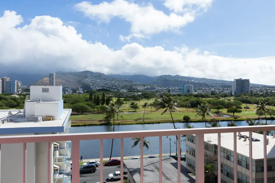 Balcony view of mountains, canal, palms, and golf greens at Ilima Hotel.