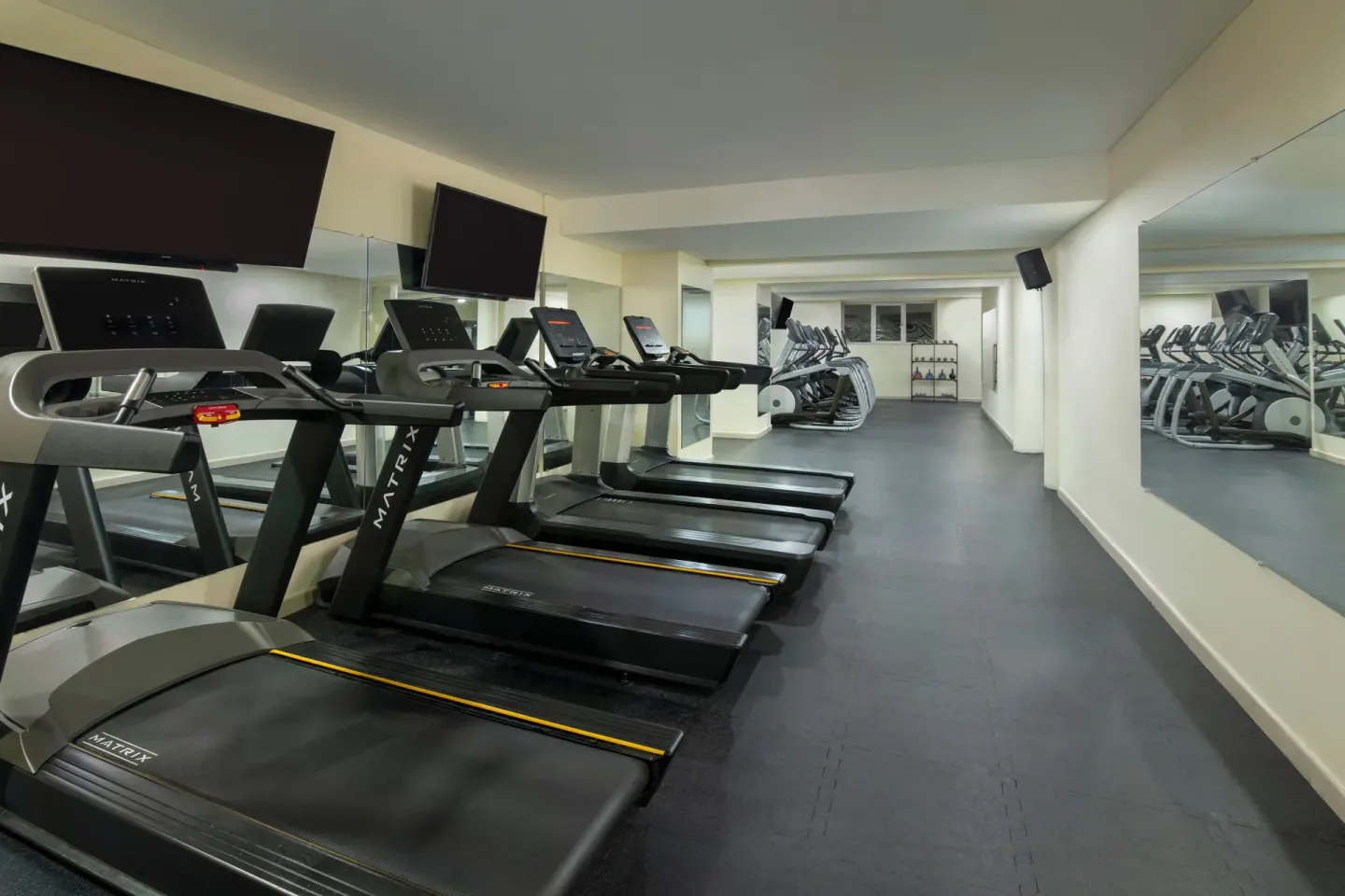 Fitness room with treadmills and mirrored walls at Impressive Premium Punta Cana.