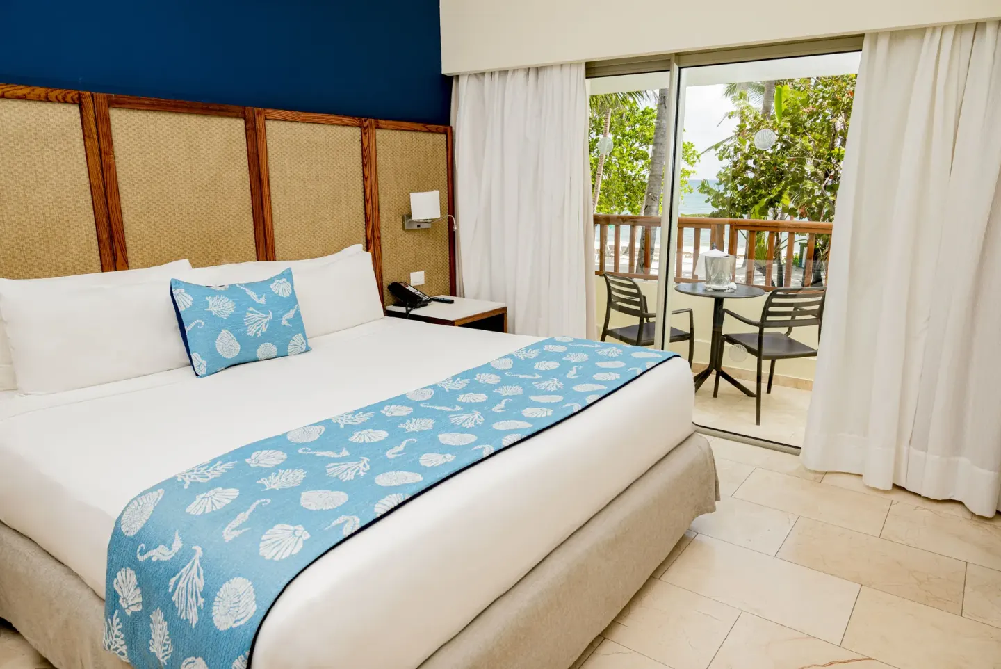 Guest room with king bed and balcony seating by the beach at Impressive Premium Punta Cana.