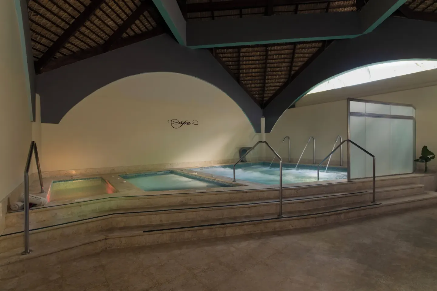 Indoor hydrotherapy pools with steps and railings at Impressive Premium Punta Cana.