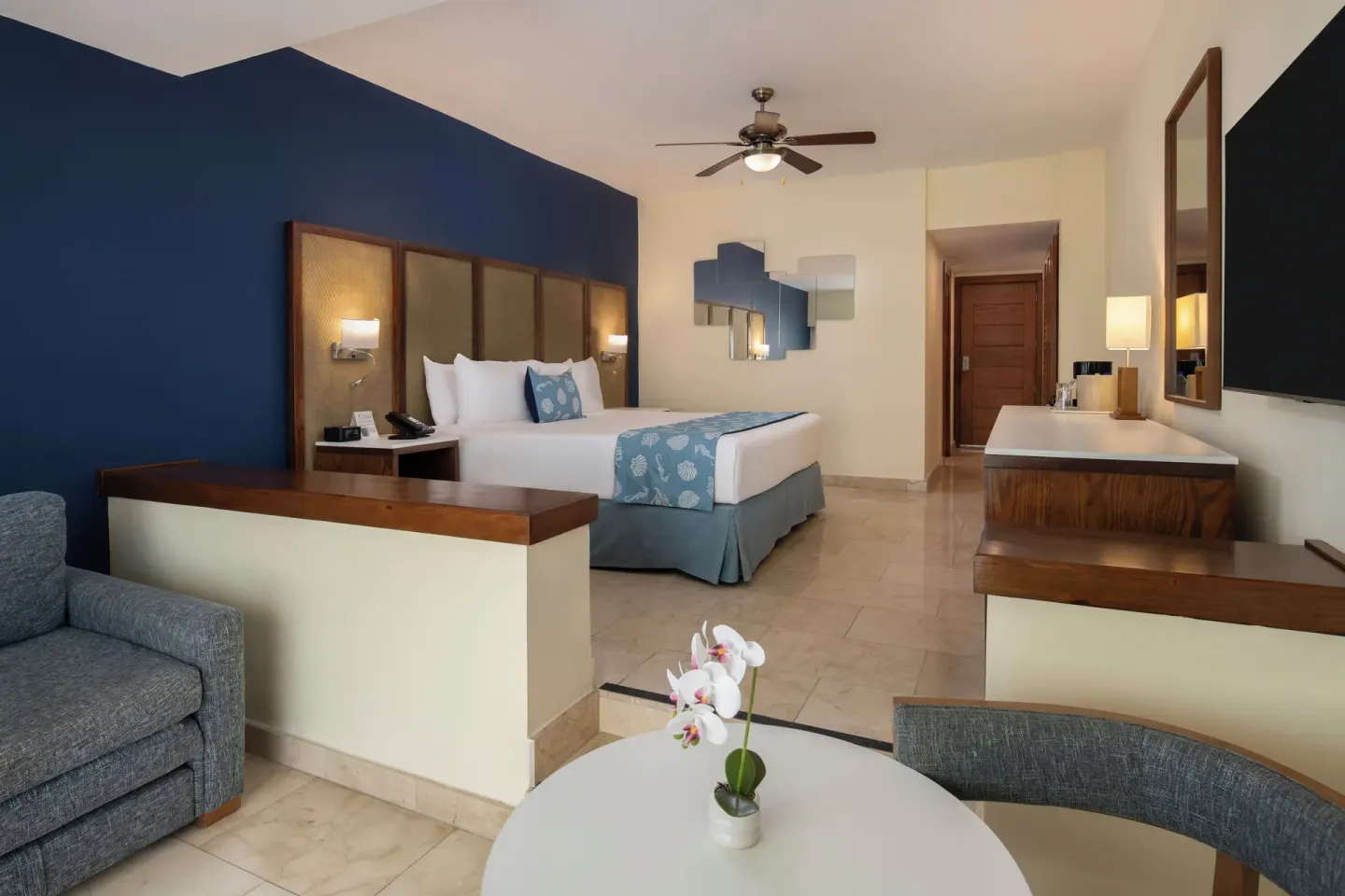 Guest room with king bed and lounge seating at Impressive Premium Punta Cana.