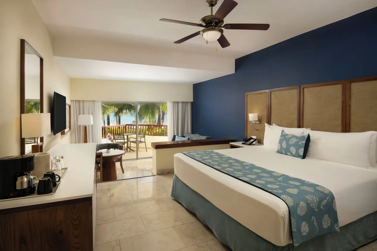 King-bed guest room with sitting area and balcony at Impressive Premium Punta Cana.