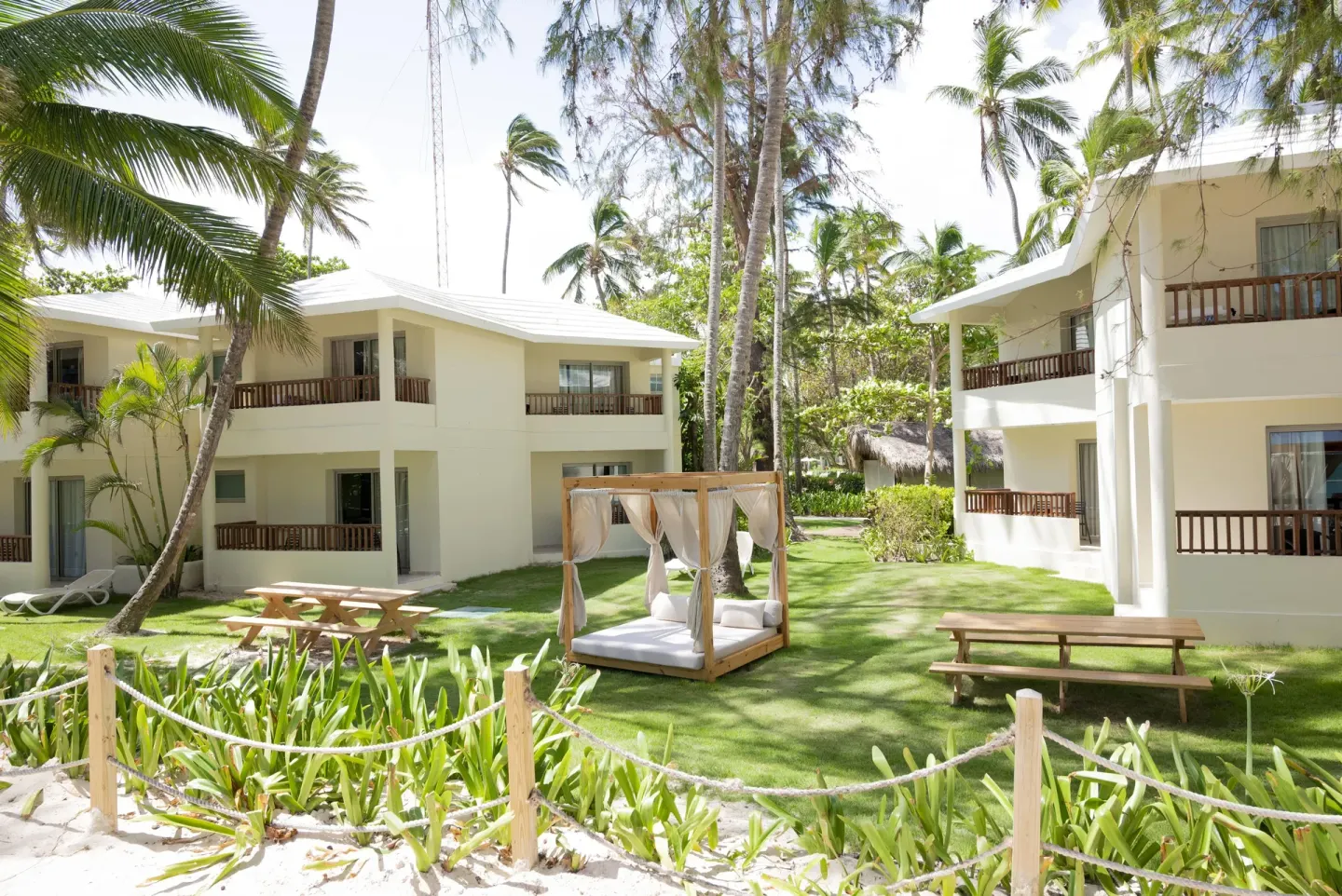 Resort lawn with cabana bed between guest buildings at Impressive Premium Punta Cana.