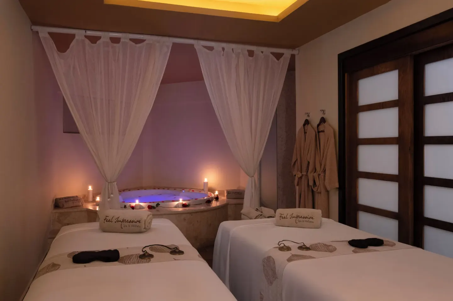 Twin spa treatment beds and a candlelit tub at Impressive Premium Punta Cana.