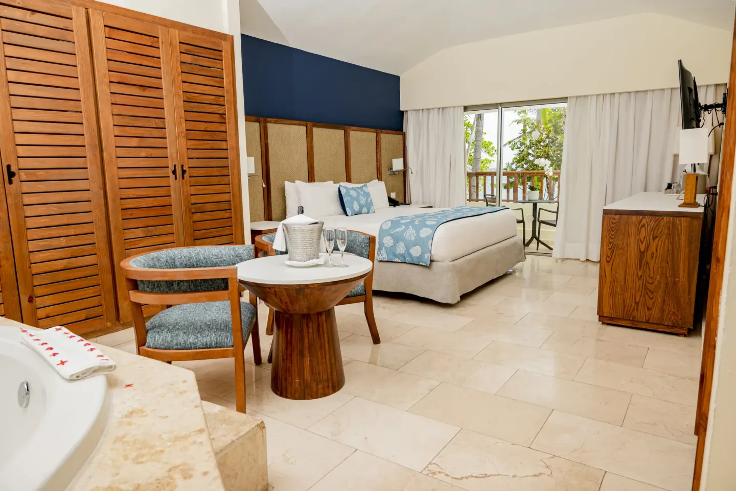 Spacious king-bed guest room with seating area and balcony at Impressive Premium Punta Cana.