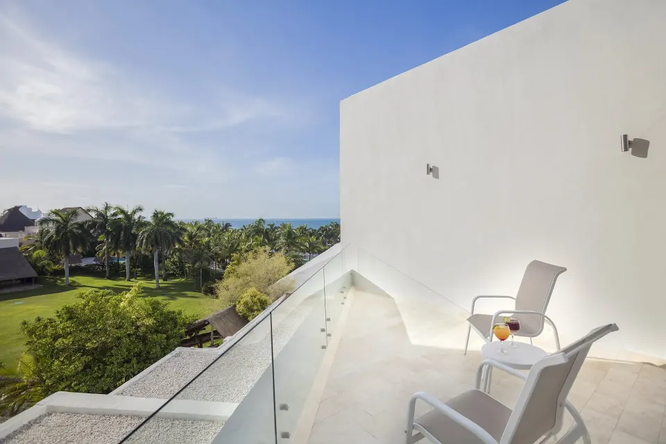 Balcony with chairs, drinks and garden-to-sea view at InterContinental Presidente Cancun Resort.