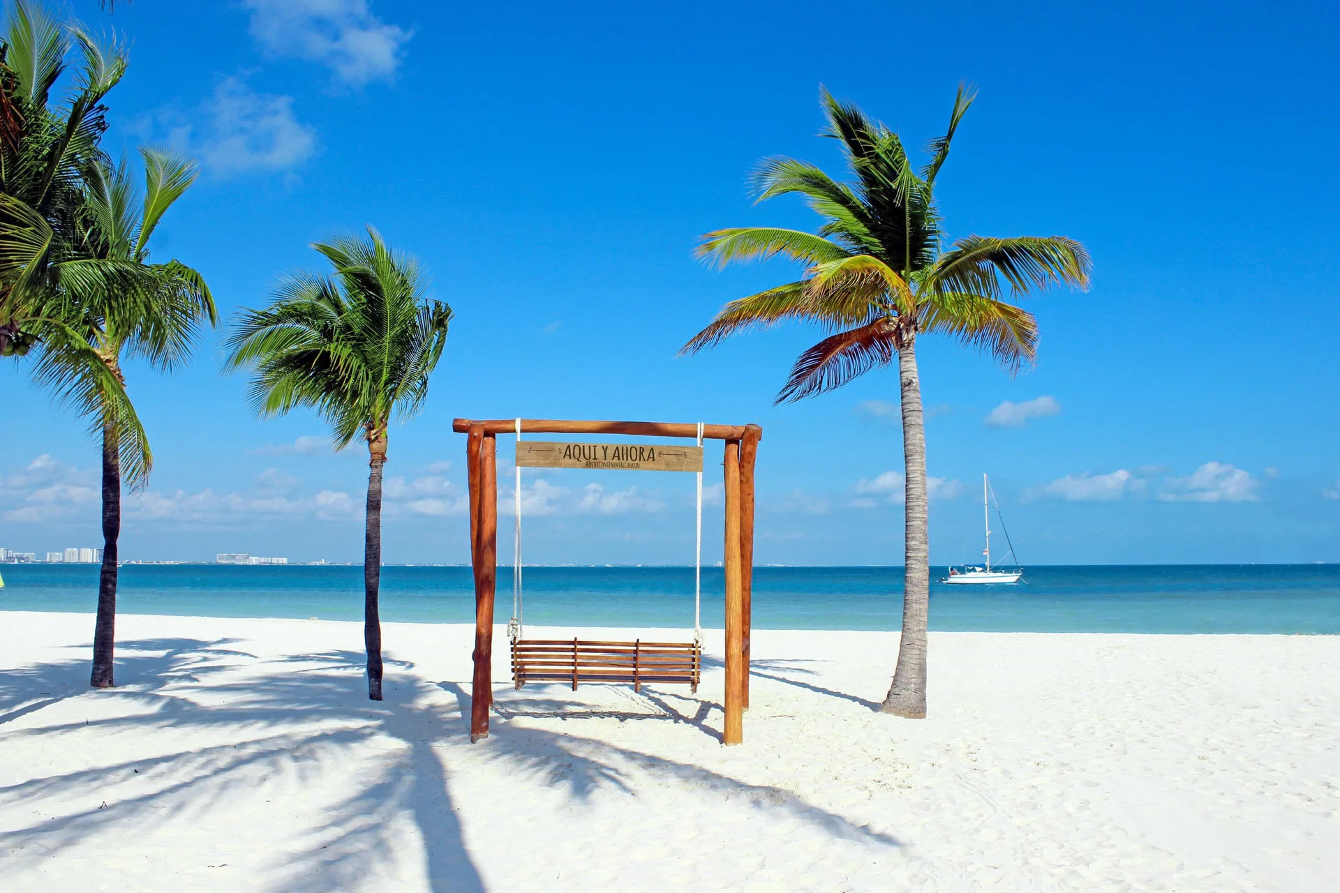 Beach swing between palm trees at InterContinental Presidente Cancun Resort.