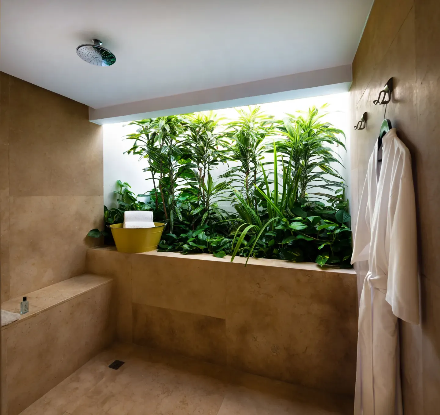 Stone shower with plants and robe at InterContinental Presidente Cancun Resort.