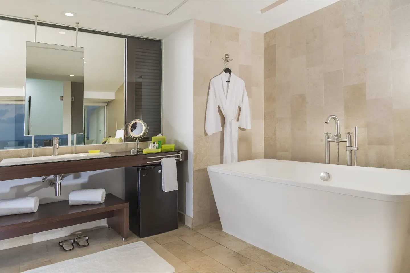 Guest bathroom with oval tub and robe at InterContinental Presidente Cancun Resort.
