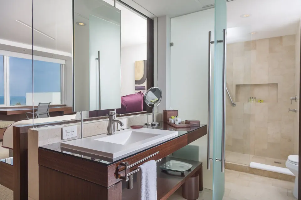 Guest bathroom sink and walk-in shower at InterContinental Presidente Cancun Resort.