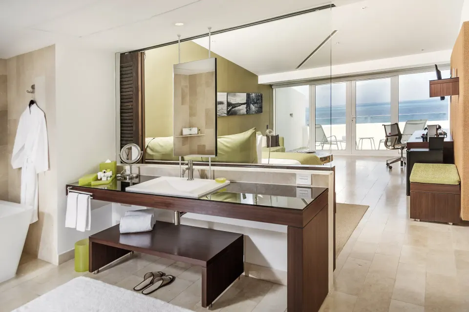 Open guest room bathroom and ocean-facing balcony at InterContinental Presidente Cancun Resort.