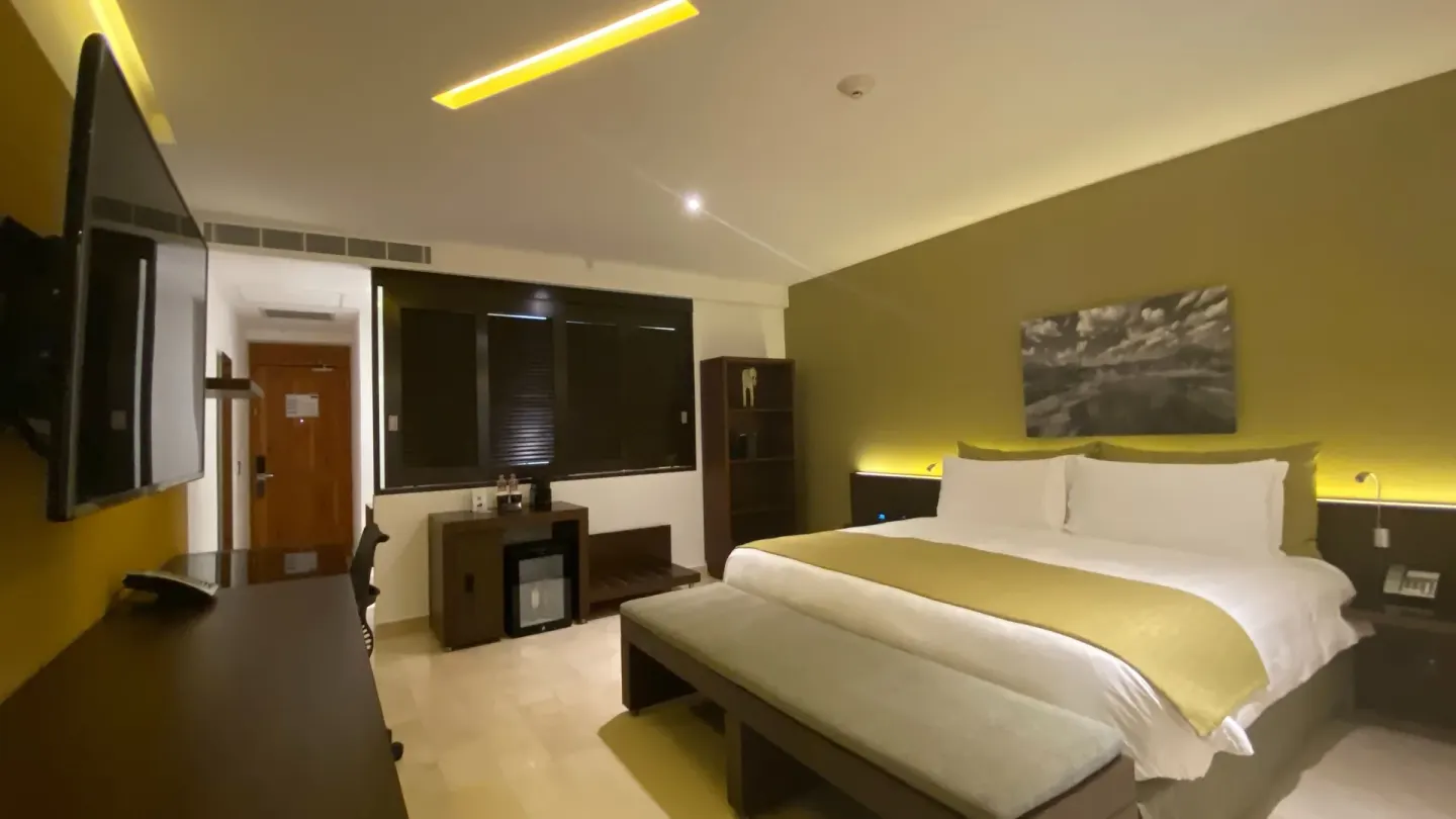 King bed guest room with green accent wall at InterContinental Presidente Cancun Resort.