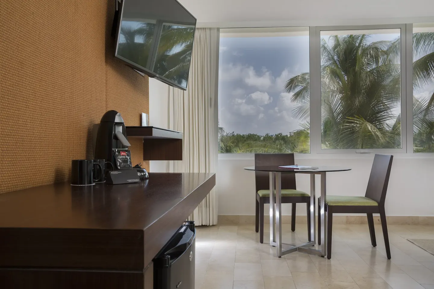 Guest room dining table, TV and coffee station at InterContinental Presidente Cancun Resort.