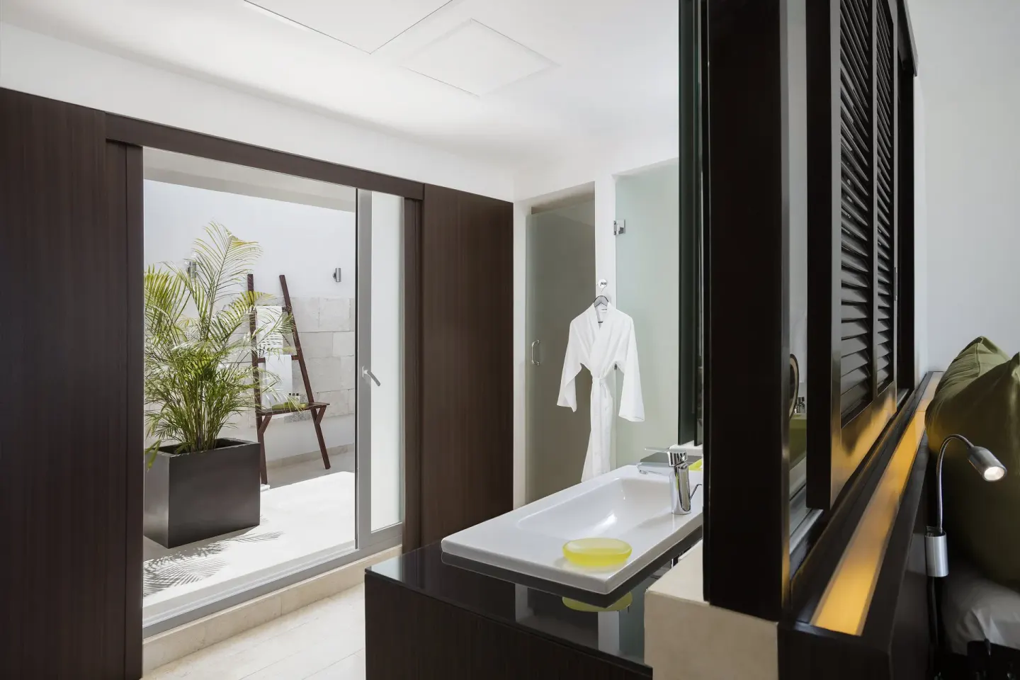 Guest room vanity with patio and robe at InterContinental Presidente Cancun Resort.