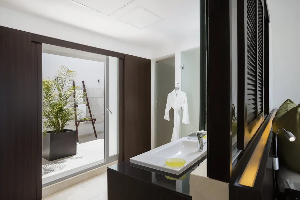 Guest room vanity with patio and robe at InterContinental Presidente Cancun Resort.