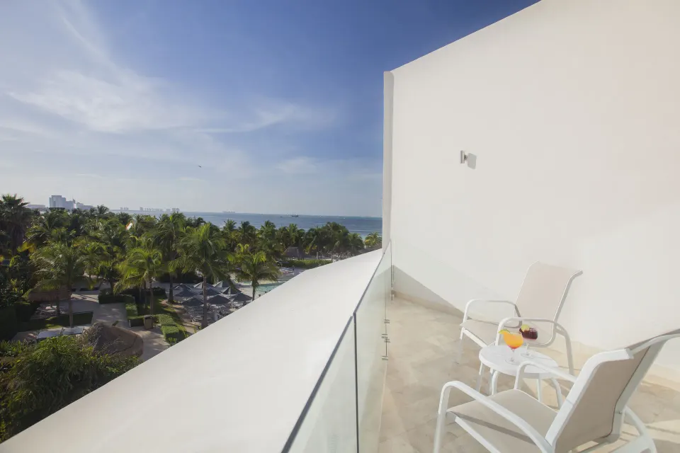 Balcony seating with ocean and palms at InterContinental Presidente Cancun Resort.