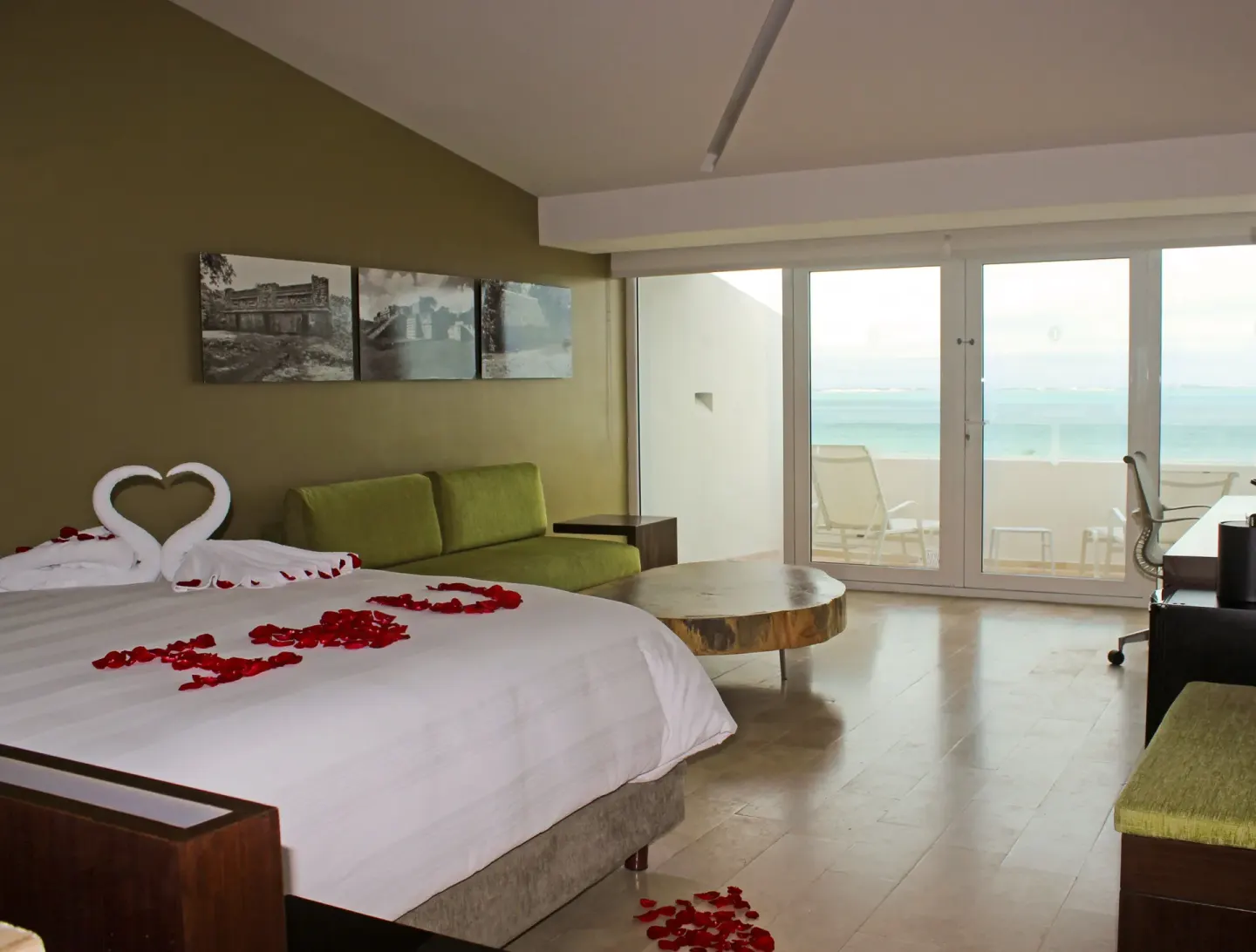 King bed with rose petals and balcony ocean view at InterContinental Presidente Cancun Resort.