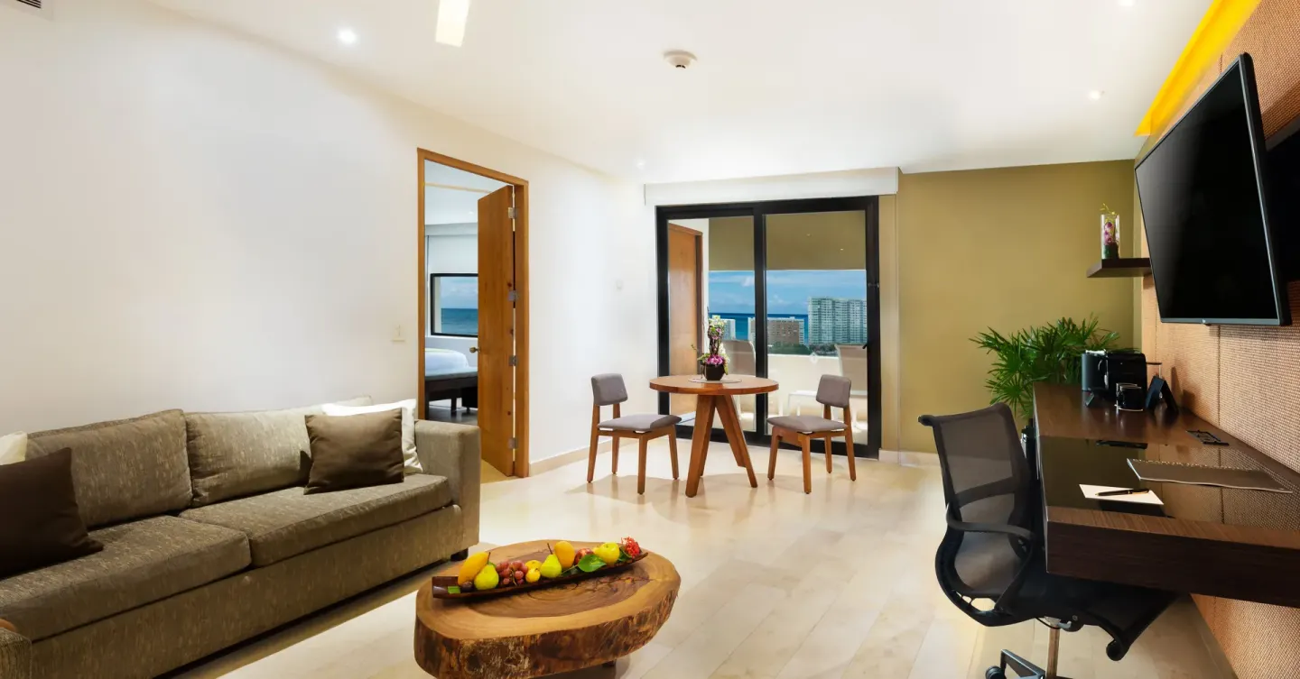 Suite living area with sofa, desk, and balcony view at InterContinental Presidente Cancun Resort.