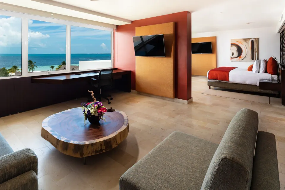 Suite living area and king bed with ocean-facing windows at InterContinental Presidente Cancun Resort.