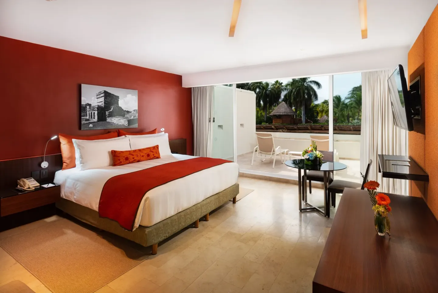 King room with red accent wall and terrace seating at InterContinental Presidente Cancun Resort.