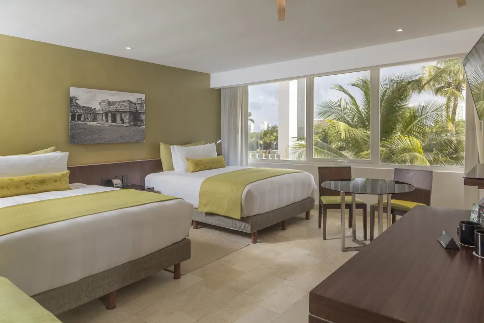 Two-bed guest room with palm view at InterContinental Presidente Cancun Resort.
