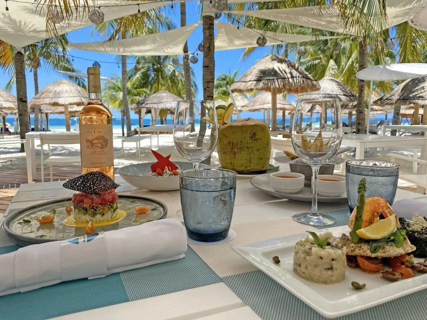 Seafood dishes and wine on a beachside table at InterContinental Presidente Cancun Resort.