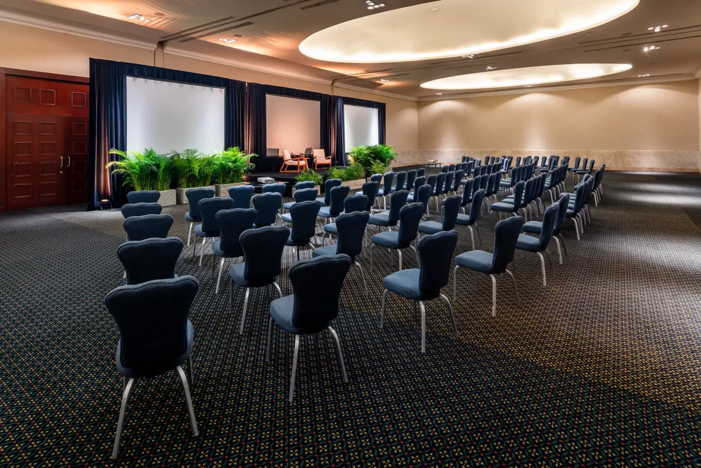 Conference room with rows of chairs and projection screens at InterContinental Presidente Cancun Resort.