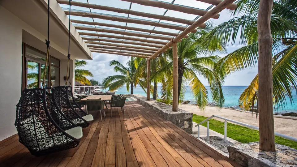 Shaded beachfront wooden deck with hanging chairs and sea view at InterContinental Presidente Cozumel Resort Spa