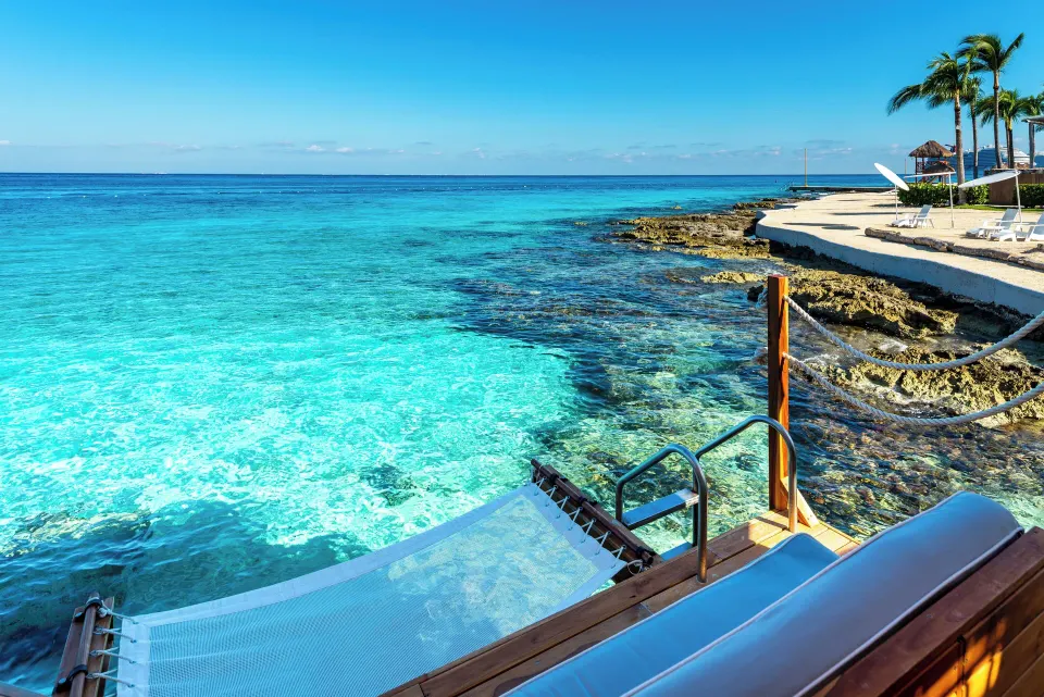 Turquoise shoreline with hammock platform and resort walkway at InterContinental Presidente Cozumel Resort Spa