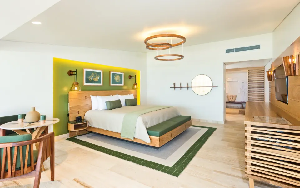 Contemporary king room with green accent wall and seating at InterContinental Presidente Cozumel Resort Spa