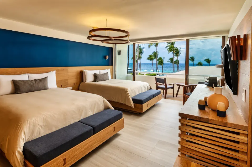 Guest room with two beds and sliding doors to a terrace overlooking the sea at InterContinental Presidente Cozumel Resort Spa