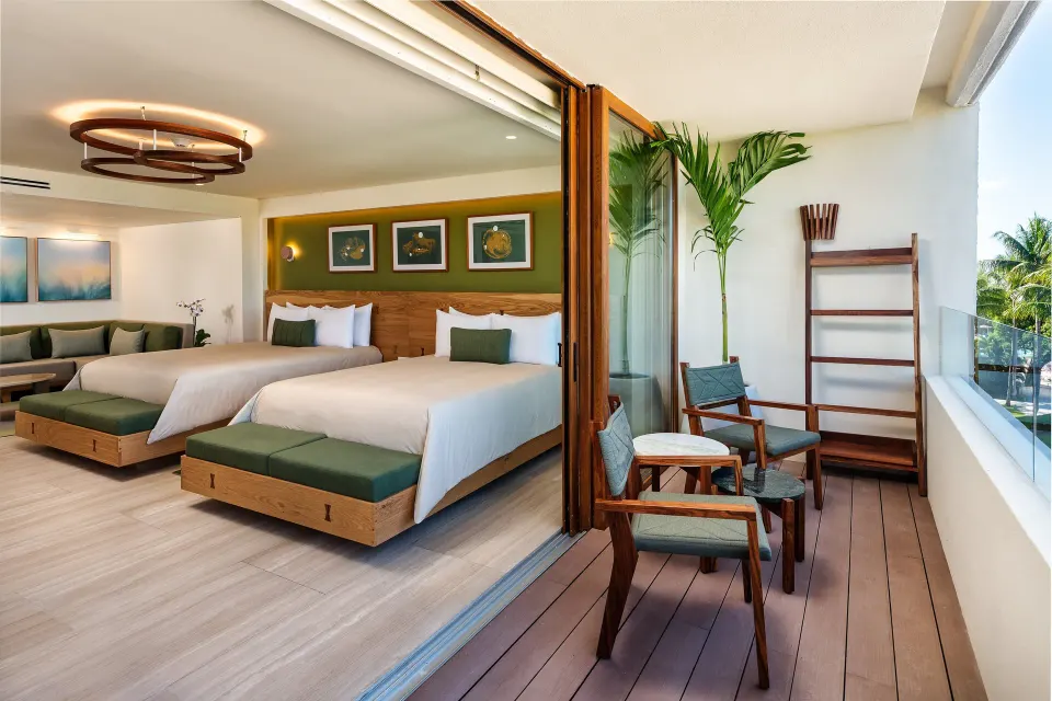 Two beds and balcony seating in a guest room at InterContinental Presidente Cozumel Resort Spa