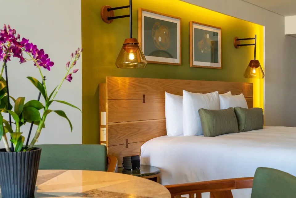 Close-up of a king bed headboard and bedside table with orchid at InterContinental Presidente Cozumel Resort Spa