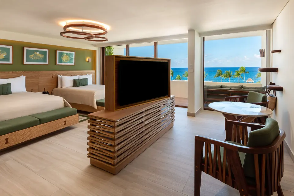 Two beds, round table and ocean view from a room at InterContinental Presidente Cozumel Resort Spa