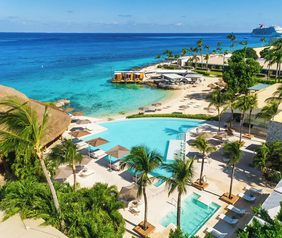 Resort pool and small sandy beach with ocean beyond at InterContinental Presidente Cozumel Resort Spa