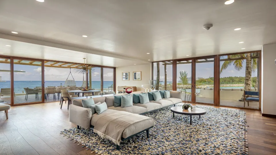 Large living area with sectional sofa and floor-to-ceiling windows looking toward the ocean at InterContinental Presidente Co