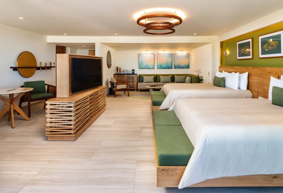 Wide view of a guest room with twin beds, sofa and TV at InterContinental Presidente Cozumel Resort Spa