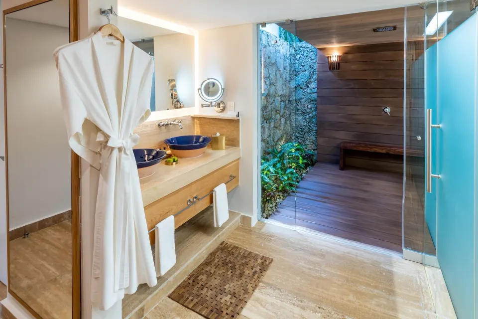 Bathroom vanity and robe with open outdoor shower area at InterContinental Presidente Cozumel Resort Spa