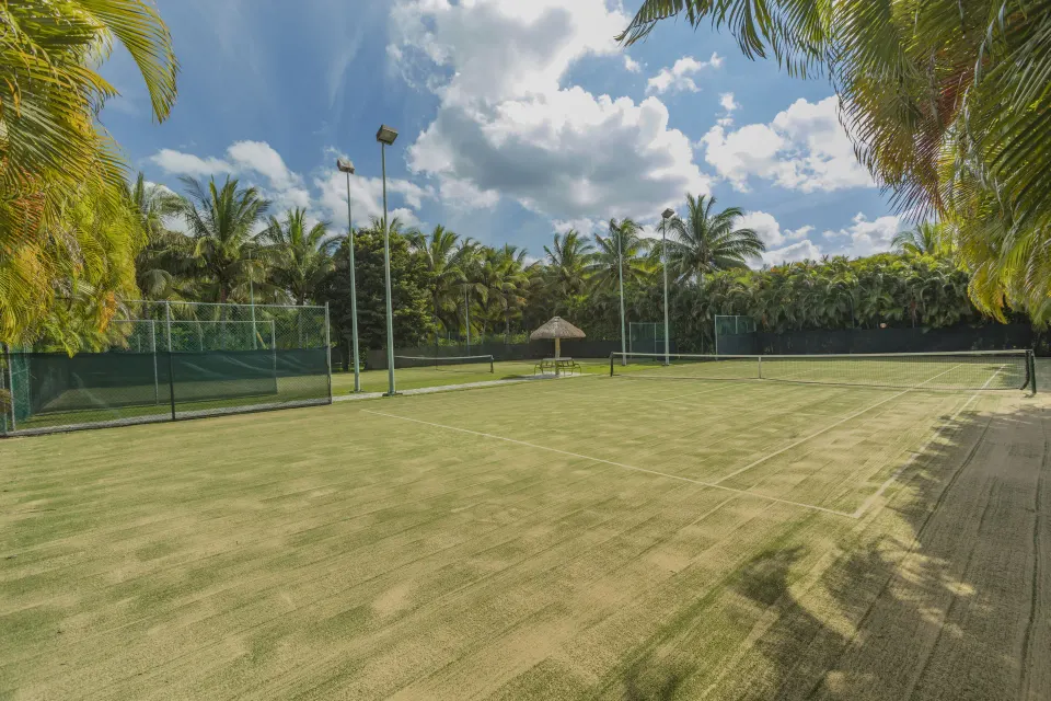 Outdoor tennis court surrounded by palm trees at InterContinental Presidente Cozumel Resort Spa