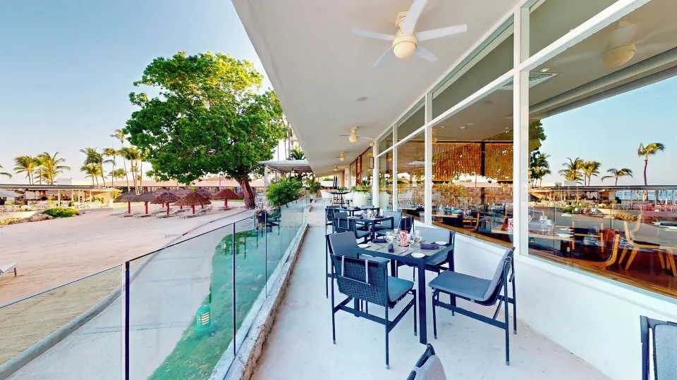 Terrace seating with glass balustrade overlooking the beach and resort grounds at InterContinental Presidente Cozumel Resort 